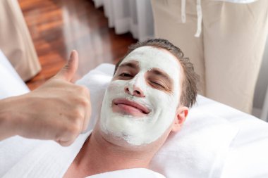 Kaplıca salonunun sakin atmosferi, insan müşterisi modern gün ışığında lüks yüz kremi masajıyla kendini yenileme zevkine kapılıyor. Yüz bakımı ve güzellik konsepti. Sessiz.