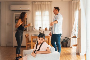 Sinirli ve mutsuz genç bir kız oturma odasında ebeveyninin tartışması yüzünden gerginliğin ortasında kanepede oturuyor. Sağlıksız ev hayatı ve travmatik çocukluk depresyona dönüşür.