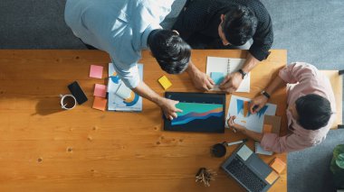 Yönetici, toplantı odasındaki meslektaşlarına mali grafiği açıklar. Farklı pazarlama ekibinin tabletle masada otururken fikir ve planlama stratejisini en üst düzeyde paylaşması. Cemaat.