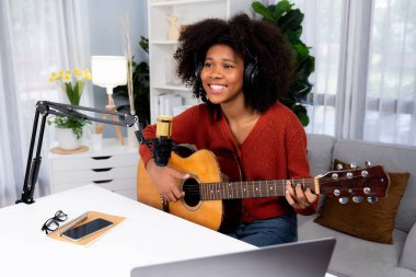Yayın stüdyosunda gitar çalarak şarkı söyleyen Afrikalı güzel bir kadının sunucu kanalı. Canlı sosyal medyada müzik blogcusu zamanı. Ses yaratıcısı kavramı. Tatlandırıcı.