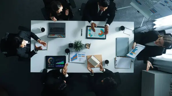 stock image Top view of smart executive manager holding stock market investment chart while planning marketing strategy with diverse group. Smart business team brainstorming and working together. Directorate.