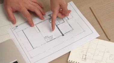 Akıllı mimar ve akıllı mühendisin dizüstü bilgisayarlı videosu mimarlık bürosundaki inşaat isabet planı hakkında tartışıyorlar. Eline odaklan. - Yakın çekim. Tanımlama.