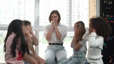 Farklı öğrencilerle çevrili yerde birlikte otururken, zeki beyaz bir öğretmen ders veriyor. Çok kültürlü bir öğrenciyle oynayan profesyonel bir eğitmen. Yaratıcı eğitim konsepti. Etkinlik.