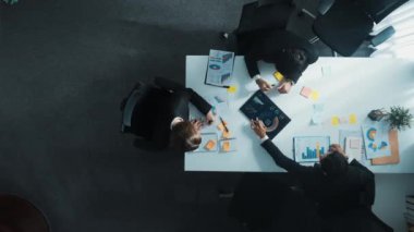 Akıllı iş adamlarının yukarıdan aşağıya bakış açısı toplantıda yatırım grafiği hakkında tartışırken yönetici müdür toplantıya katılıyor. Mutlu pazarlama ekibi masadaki finansal veri tablosunu analiz etsin. Müdürlük.