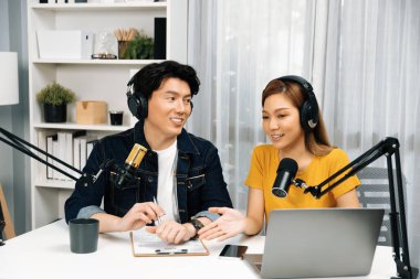 Gülümseyen radyo etkili sunucular, kulaklık takarak sosyal medya kanalından canlı yayın yapıyorlar ve sabah saatlerinde stüdyo kaydında dinleyicilere konu ve dizüstü bilgisayar üzerinden konuşuyorlar. İnfobahn.