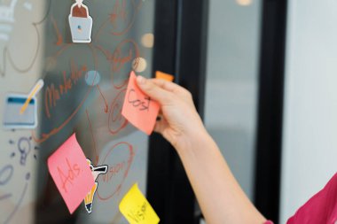 Profesyonel iş kadınının elini kapat ve iş planını sunarken renkli yapışkan notları beyaz tahtaya yapıştır. Yaratıcı iş toplantısı ve beyin fırtınası konsepti. Tertemiz..