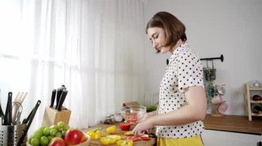 Kafkaseli anne kahvaltıda sebze pişirirken mutlu anne de modern mutfakta salata için taze malzemeler hazırlıyor. Hizmetçi sağlıklı yemek pişiriyor. Dikkat konsepti. Pedagoji.