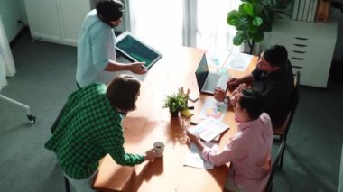 İş adamlarının görüşleri pazarlama ekibi toplantısına katılırken tartışır. Yönetici, iş arkadaşları telefon ve beyin fırtınası fikrini kullanarak yatırımcıyla konuşurken finansal grafiği işaret ediyor. Cemaat.