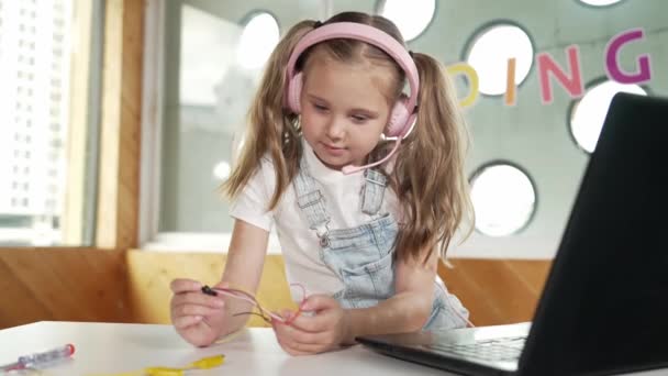 Dziewczyna Nosząca Słuchawki Podczas Nauki Sprzętu Patrząca Kamerę Białe Dziecko — Wideo stockowe