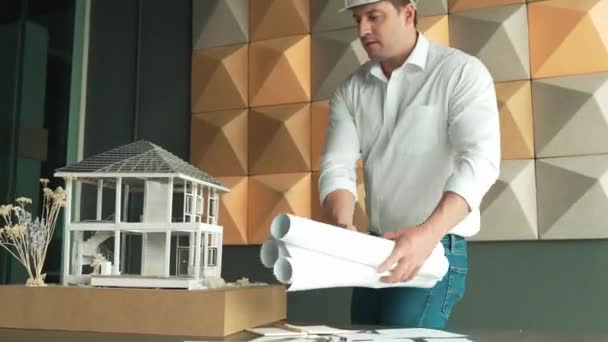 专业的高加索男性建筑工程师用项目计划和建筑模型对房屋模型的建造进行检查和检查 商业设计概念 机械手 — 图库视频影像