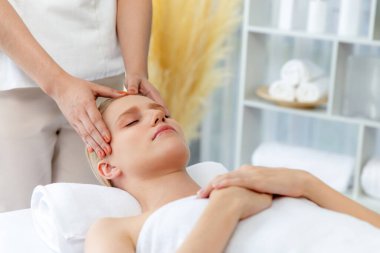 Kafkasyalı kadın stres önleyici kafa masajından ve lüks tatil beldesi ya da otel spa salonundaki modern ışık ortamında yüz güzelliği eğlencelerini şımartmaktan hoşlanıyor. Sessiz.