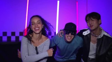 Çok kültürlü break dans takımı mor neon ışıkla stüdyoda müzik yapıyor. Stüdyoda farklı arkadaşlara bakarken serbest dans eden enerjik sokak dansçıları grubu. Çılgınca. Mutluluk.