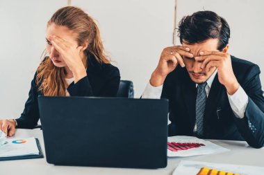 Mutsuz ciddi iş adamı ve iş kadını ofis masasında dizüstü bilgisayar kullanarak çalışıyor. Kötü iş krizi ve iflas konsepti. uds