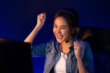 Sunucu kanalı Asyalı etkileyicisi canlı yayında konuşuyor. Sosyal medyada kulaklık takıyor, bilgisayar kaydı yapıyor, dinleyicileri selamlıyor ve Neon Modern Stüdyoları 'nda online olarak koçluk yapıyor. Taktik.