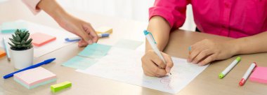 Profesyonel iş kadını iş dünyasının zihin haritasını çiziyor. Yaratıcı kadın girişim lideri, fikir üretmek için kalem ve yapışkan notlar kullanarak pazarlama planları hazırlıyor. - Yakın çekim. Eline odaklan. Değiştirilmiş.