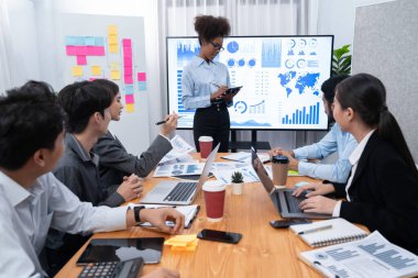 Genç Afrikalı iş kadını modern toplantıda TV ekranında veri analizi paneli sunuyor. Bir grup iş adamıyla konferans odasında iş sunumu. Uyum