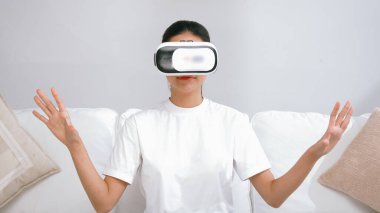 Canlı online alışveriş deneyimi için sanal gerçeklik gözlüğü kullanan genç bir kadın. Sanal gerçeklik VR yeniliği kadın dijital eğlence yaşam tarzı için optimize edildi.