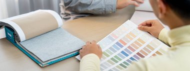 Profesyonel mimar ve iç mimar perde malzemesi ve renk paletinin uygun rengi hakkında tartışıyorlar. Yetenekli iç mimar müşteriye malzeme sunar. - Yakın çekim. Değiştirilmiş.