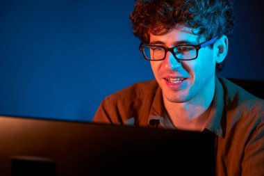 Genç işadamı, Neon Light Modern Ofis 'te yaratıcı bir başlangıç projesi için bilgisayara odaklanıyor. Düşünüyorum da, pazarlama ağı yaratıcıdan pazar kanalı tasarım konseptine çevrimiçi planlama. Toplayıcı.