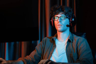 Stresli genç oyun flaması takımı, Esport ile çevrimiçi olarak bilgisayar üzerinde daha sert oyun seviyesine odaklanmış ve neon aydınlatma odasında strateji planı uygulamak için sürpriz yüz ifadesiyle kazanmayı denemiştir. Toplayıcı.