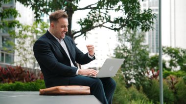 Kafkas proje yöneticisi dizüstü bilgisayarı üzerinde çalışıyor ve yeşil kentsel kentteki bankta otururken yaptığı başarıyı kutluyor. İş adamı rapor yazıyor ve iş ekibiyle fikir alışverişinde bulunuyor. Urbane.