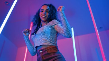 Latin dansçıların kameraya bakıp şehrin pop müziğiyle dans ettiği düşük açılı kamera. Profesyonel çekici hipster, mor veya neon ışıklı hip hop şarkısına geçiyor. Şık bir kumaş. Mutluluk.