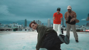 Becerikli hipster şehirde çok kültürlü dansçılarla dans ediyor. Arkadaş performans ararken çekici break dansçı çatıda sokak dansı yapıyor. Açık hava sporu 2024. ÇalışmaComment.