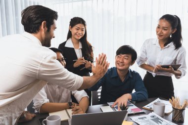 Çeşitli ofis çalışanlarından oluşan bir grup, stratejik iş pazarlama planlaması konusunda anlaşma yaptıktan sonra beşlik çaktı. Takım çalışması ve olumlu tutum verimli ve destekleyici bir iş yeri yaratır. Tedbirli
