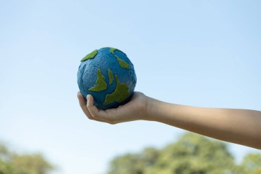 Dünya gezegenini ESG ilkesi ve çevre dostu enerjisiyle daha parlak bir gelecek için Dünya günü olarak tutan genç çocuklar. Döngü