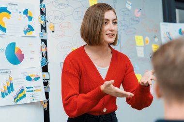 Profesyonel çekici kadın lider, modern iş toplantı odasında beyin fırtınası zihin haritalama istatistikleri ve renkli yapışkan notlar kullanarak yaratıcı pazarlama planını sunuyor. Tertemiz..