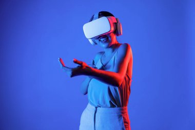 VR kulaklık takan zeki bir kadın metaevrene bağlanıyor, gelecekteki siber uzay topluluğu teknolojisi. Sanal silaha hükmeden zarif bir kadın ciddi ciddi oyun oynuyor. Halüsinasyon.