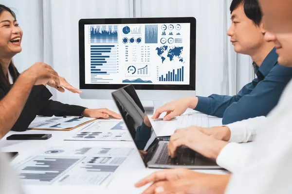 stock image Analyst team utilizing BI Fintech to analyze financial data at table in meeting room. Businesspeople analyzing BI dashboard power for business insight and strategic marketing planning. Prudent