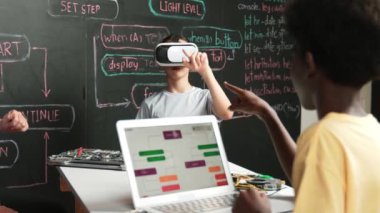 Afrikalı erkek programlama sistemi, beyaz bir kız karatahtanın başında mühendislik kodlarıyla otururken metaverse 'e giriyor. Liseli kız STEM teknolojisinde VR ya da kulaklık takıyor. Öğretim