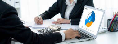 İş istihbarat analisti ekibi bilgisayardaki BI yazılımını kullanarak finansal veri gösterge panelini analiz ediyor. İş teknolojisi, şirket yöneticilerini panoramada stratejik kararlar vermeye teşvik ediyor. Kurnaz.