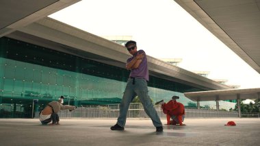 Çeşitli hipster grupları ya da sokak dansçıları alışveriş merkezinin önünde kafa sallıyorlar. Mutlu enerjik break dansçıları arkadaşlarıyla break dans yapıyor. Açık hava sporu 2024. Sokak dansçısı konsepti. Yumuşak bir şekilde..