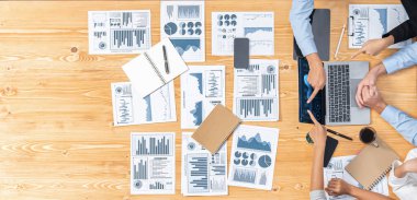 Panorama üst düzey iş analist grubu toplantı masasındaki finansal veri raporunu analiz ediyor. İş zekası analizine göre çizelge ve grafik paneli. Çok titiz.