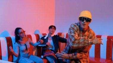 Kafkasyalı break dansçı çeşitli arkadaşlar birlikte dans ederken hareket eder. Çok kültürlü grup arkadaşını desteklemek ve cesaretlendirmek için el sallarken mutlu hipster hareketi. Mutluluk.