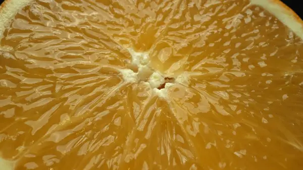 Макрографический Захват Оранжевого Фрагмента Помещенного Гладком Изолированном Черном Фоне Раскрывается Лицензионные Стоковые Изображения