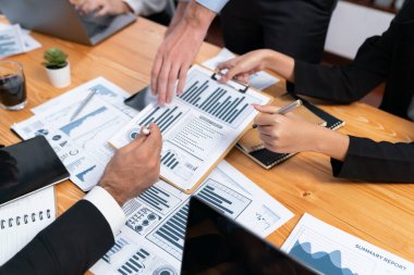 Ofis masasındaki finansal veri raporlarını analiz eden çeşitli bir grup iş analisti. Stratejik pazarlama planlaması için iş istihbarat analizine göre grafikler ve grafikler.