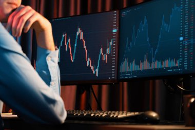 Piyasa stoku grafik veritabanında Neon Modern Ofis 'te yan manzaralı gerçek zamanlı ekranlarda çalışan genç bir tüccar. Dinamik finansal döviz kuru kavramı. Toplayıcı.