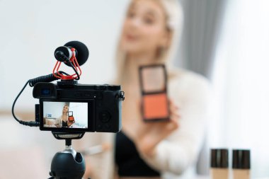 Sosyal medya için güzellik ve kozmetik video içeriği hazırlayan bulanık genç bir kadın. Güzellik etkileyicisiyle odaklanmış kamera ekranı izleyicilere ve takipçilere güzellik hizmetinin nasıl uygulanacağını gösteriyor. Blithe