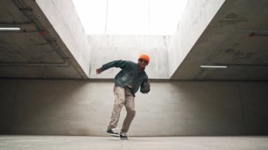 Modaya uygun mutlu hipster break dans ya da serbest dans yapıyor. Profesyonel break dansçı B-boy dansı yaparken şık kıyafetler giyiyor. Modern yaşam tarzı. Açık hava sporu 2024. Yumuşak bir şekilde..