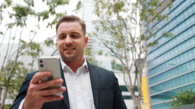 Düşük açılı kamera görüntüsü iş adamının telefonuna bakarken pazarlama ekibini arayıp Green City 'deki finansal plan hakkında fikir alışverişinde bulunması. Yönetici, iş arkadaşıyla telefonla konuşuyor. Urbane.