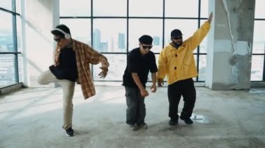 Çok kültürlü dansçılar sokak dansı yapıyor ve hip-hop müziğine geçiyorlar. Profesyonel hipster grubu gökyüzü kavgacı görünümlü bir binada serbest stil müzik eşliğinde dans ediyor. Açık hava sporu 2024 hiphop..