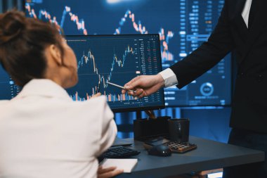 Gülümseyen Asyalı tüccarlar dinamik borsa verilerine işaret ediyor. Gece vakti internet sitesinde kar etme programı. Veri raporunda para birimi değeri analiz ediliyor. İnfobahn.