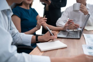 Sekreter, toplantı odasında görüşen bir grup çok ırklı iş adamıyla şirket toplantısında defterine not alıyor. Modern ofiste profesyonel toplantılarda çeşitlilik. Uyum