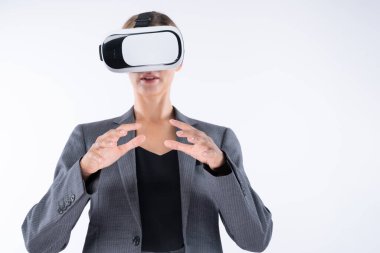 İş kadını, VR gözlük takıp beyaz arka planda dururken elinde bir şey tutuyor. Kulaklıklı proje yöneticisi görsel gerçeklik dünyasına teknolojik yenilikler kullanarak giriyor. Kısıtlanma.