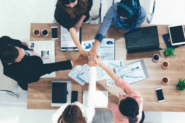 İş adamları ve iş kadınları, takım çalışması, destek ve iş birliğini gösteren çok kültürlü ofis odasındaki grup toplantılarında el ele tutuşuyorlar. Çeşitli işyerleri ve şirket çalışanları konsepti. uds