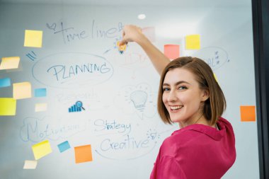 Genç ve güzel iş kadını, zihin haritası ve renkli yapışkan notla finansal sorunları çözerken cam panoya etiket yapıştırıyor. Yaratıcı iş konsepti. Tertemiz..