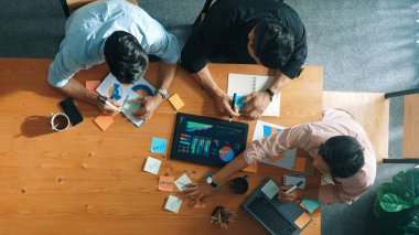 Yönetici, toplantı odasındaki meslektaşlarına mali grafiği açıklar. Farklı pazarlama ekibinin tabletle masada otururken fikir ve planlama stratejisini en üst düzeyde paylaşması. Cemaat.